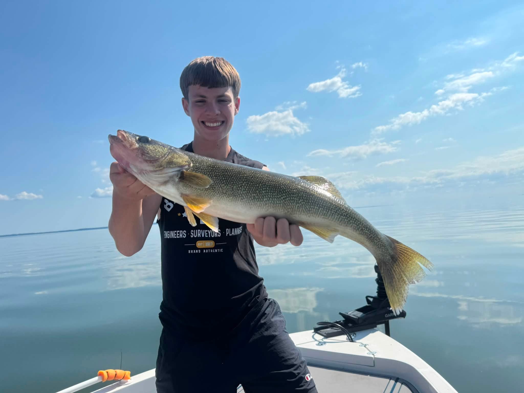 Young angler holding a large walleye aboard an Exclusively Walleye fishing charter