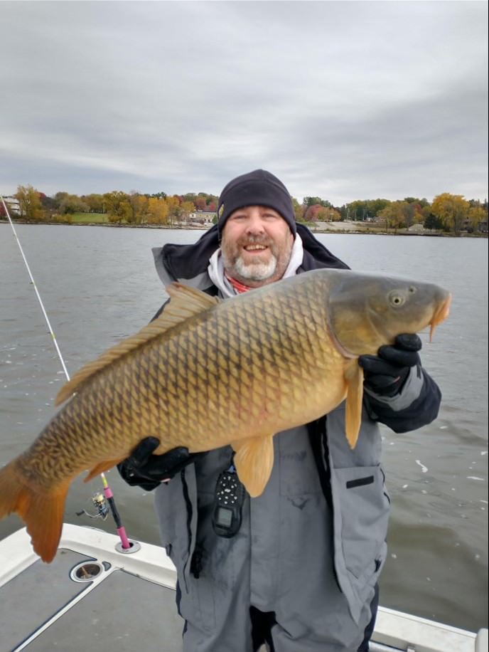 Captain Mike Lewis holding a giant carp during a fishing outing